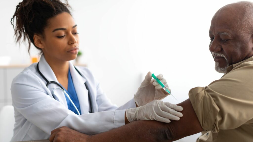 Patient receiving injection into arm by doctor.